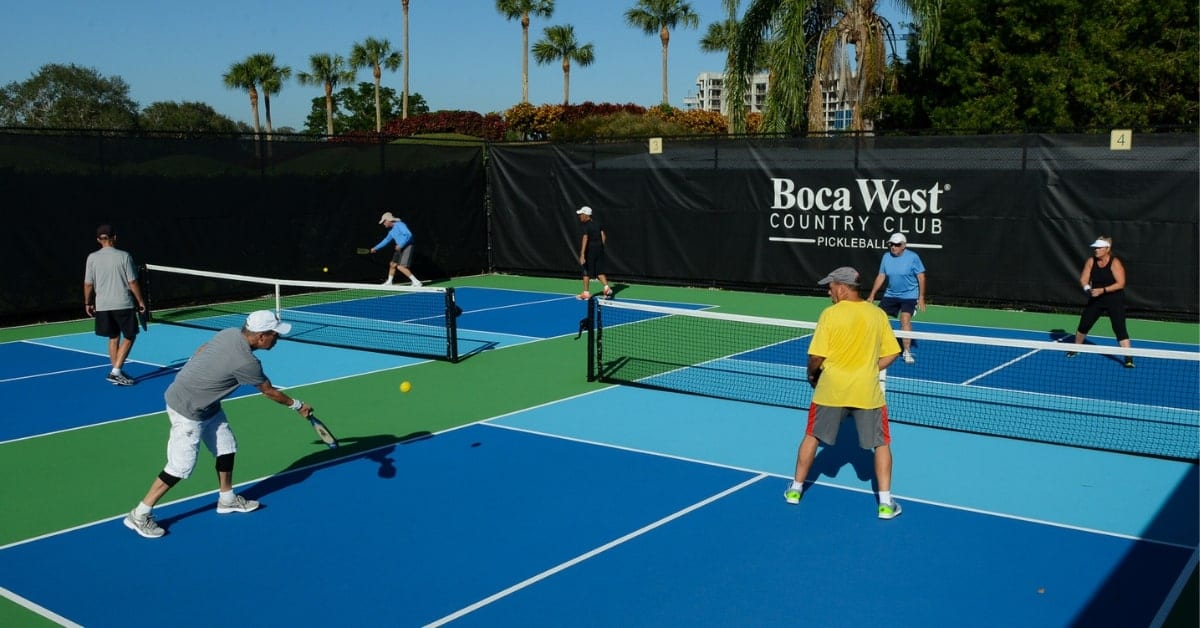 Residents playing a game of Pickleball on two of Boca West's Pickleball courts