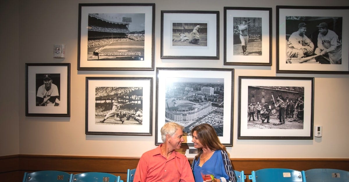 Couple seated on old Shea Stadium baseball seats at Grand Central at Boca West