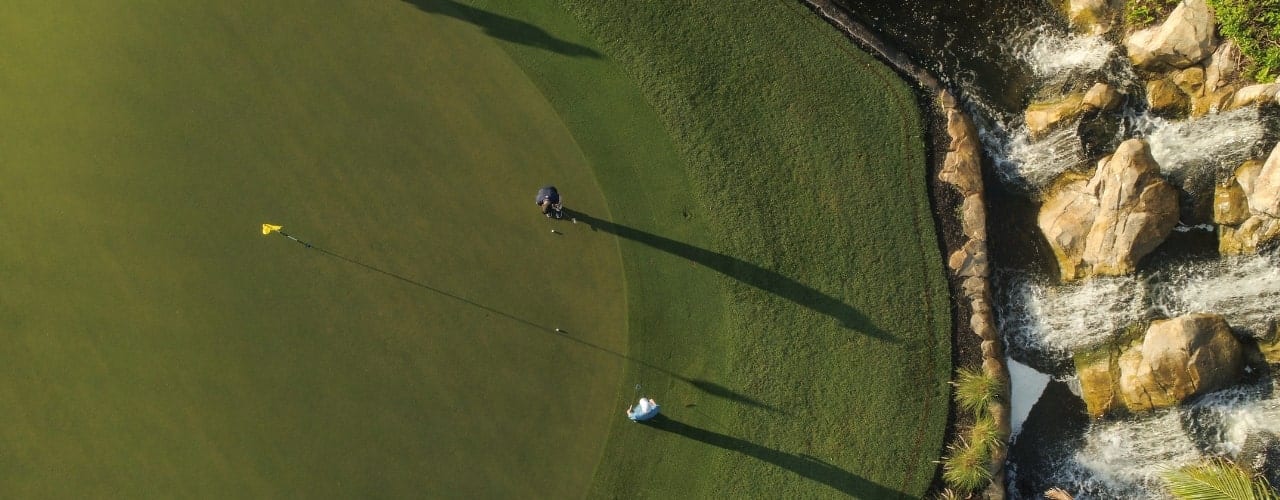 Two members play on an expansive green at Boca West