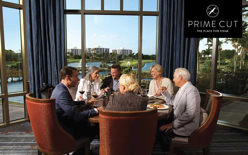 Group of people dining at Boca West's Prime Cut with view of the golf course
