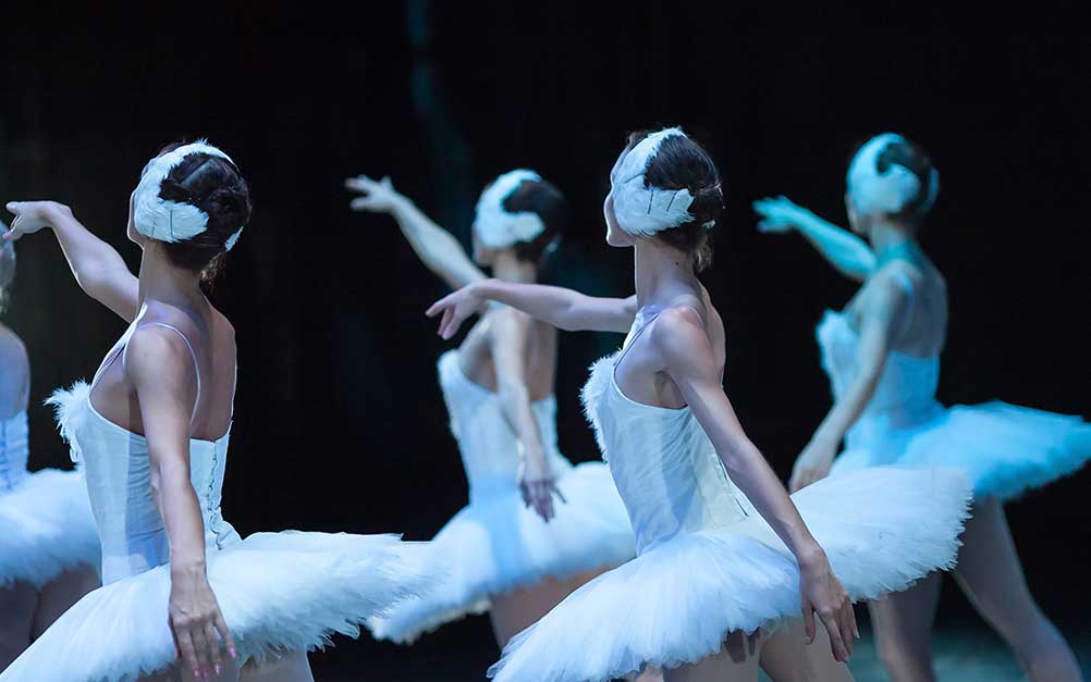 Ballet dancers performing in white costumes