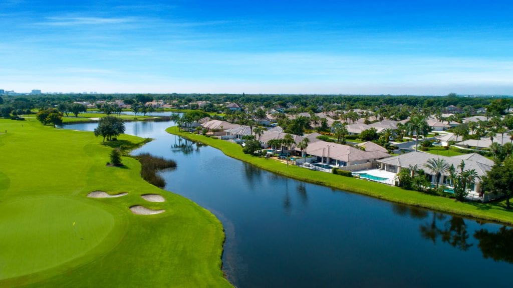 Single-family homes along canal next to golf course hole at Boca West