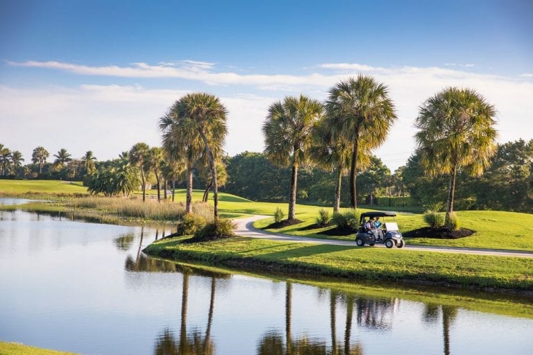 Members riding on a cart path at Boca West golf course