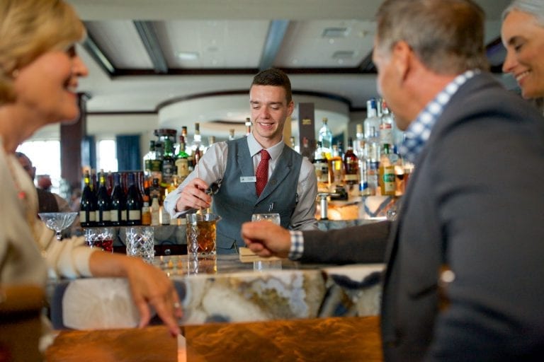 Bartender serving drinks to members at Boca West