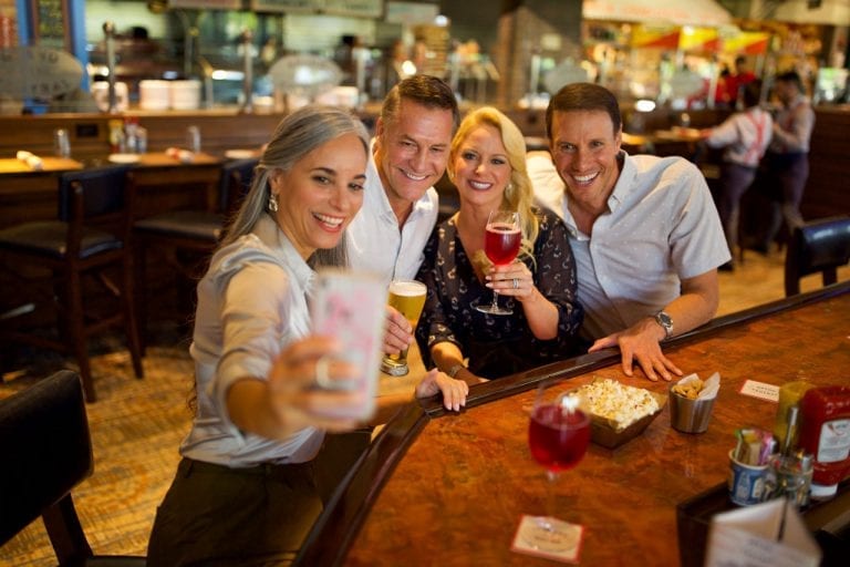 Two couples taking a selfie at Boca West bar