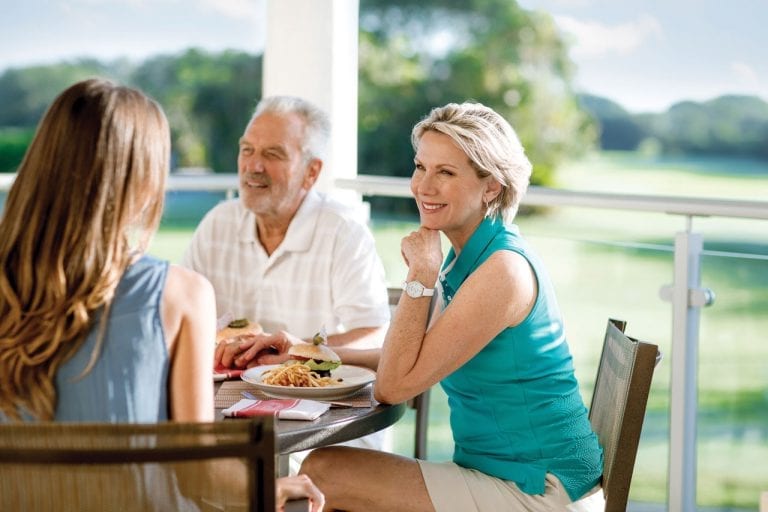 Three people enjoying a meal at Boca West