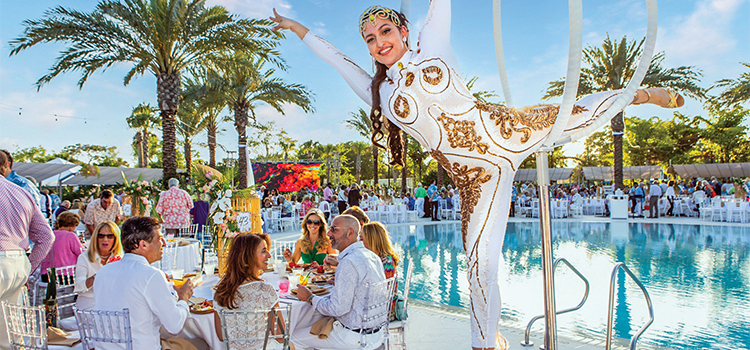 Aerial performer above pool as guests dine at outdoor country club event