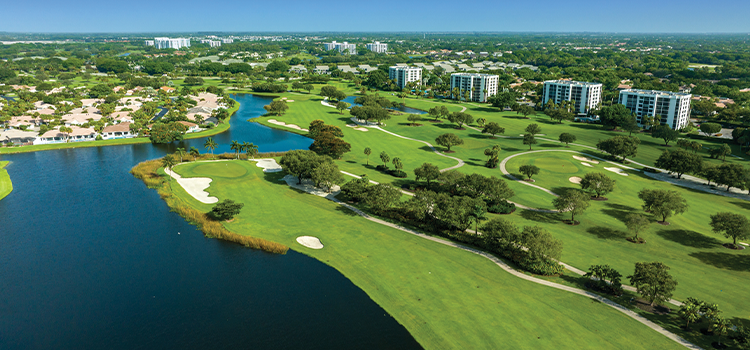 Aerial view of homes beside waterway and golf course