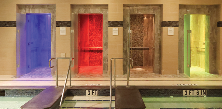 Color-lit spa steam rooms beside an indoor pool