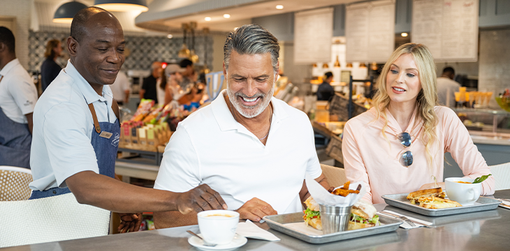 Restaurant server placing a cup on a counter as guests dine.