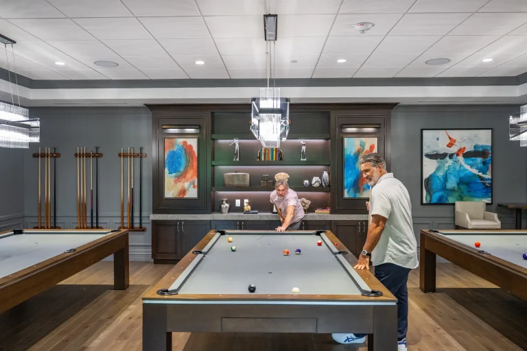 Two men playing billiards in the Boca West game room.