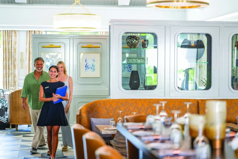 Hostess escorting members through the dining room at Boca West.