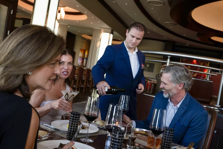 Sommelier pouring wine for members at a fine dining table at Boca West.