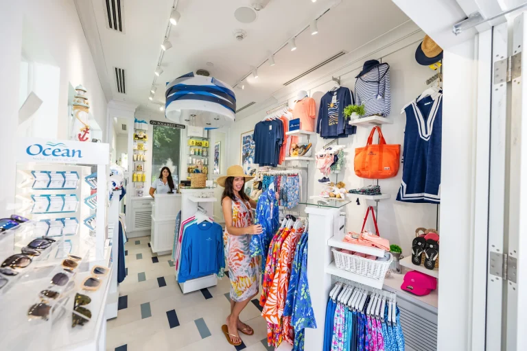 Retail display of sunglasses, jewelry, and resort wear at a Boca West boutique.